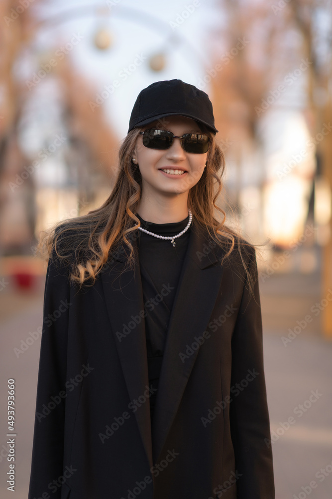 Portrait of a young beautiful blonde girl in a dark baseball cap. Portrait of a young beautiful blonde girl in a dark baseball cap.