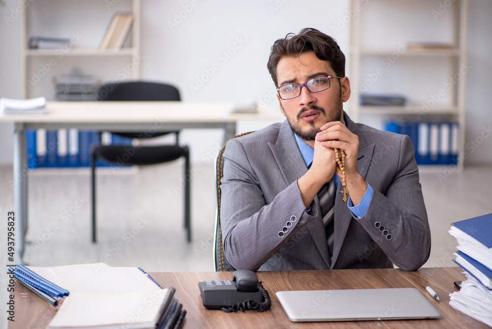 Young male employee unhappy with excessive work in the office Young male employee unhappy with excessive work in the office