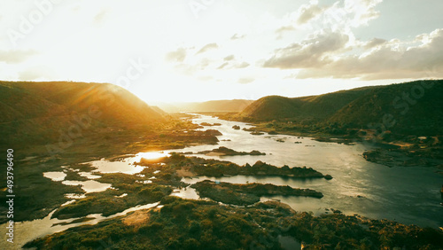 Dramatic landscape scene with mountains, lake and golden sunbeams