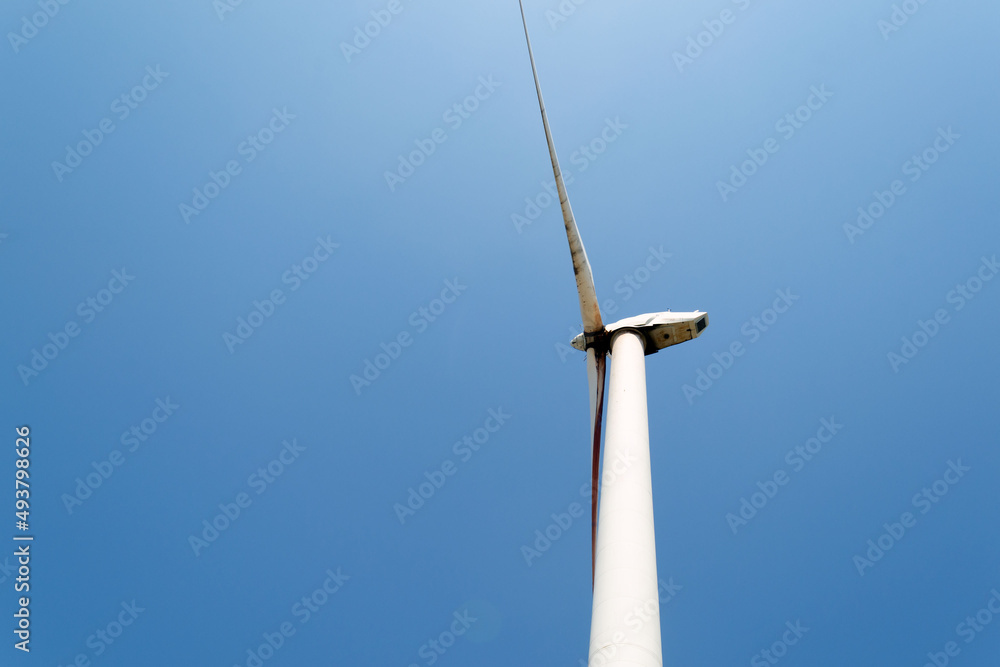 Alternative green energy sources. Wind turbine on blue sku background Alternative green energy sources. Wind turbine on blue sku background