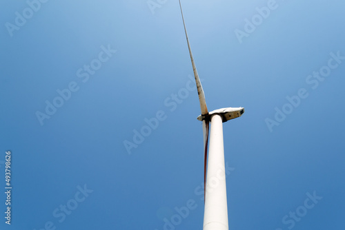 Alternative green energy sources. Wind turbine on blue sku background