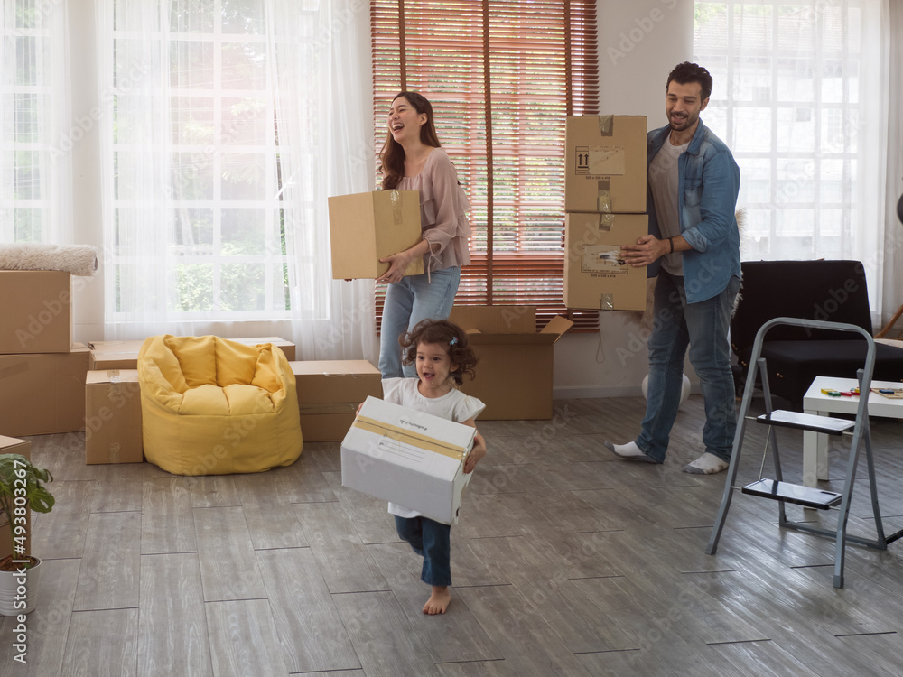 Family, mother, father and cute little toddler daughter, helping to carry all the boxes into new place. Family, mother, father and cute little toddler daughter, helping to carry all the boxes into new place.