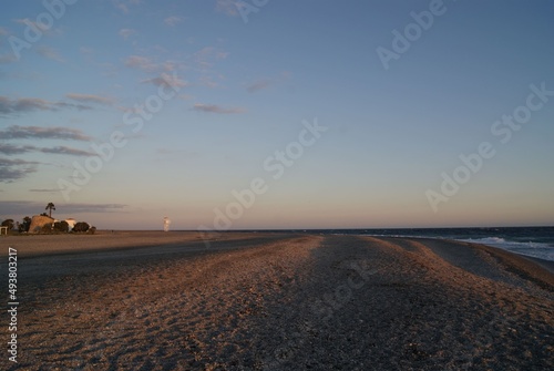 Atardecer en la playa con las olas rompiendo en la arena © javier