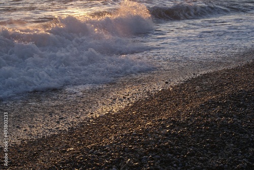 Atardecer en la playa con las olas rompiendo en la arena