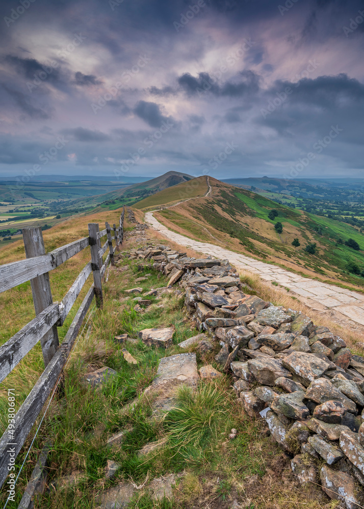 Mam Tor ridgeway, the Peak District, on a moody, cloudy summer's morning. The sky is pink where the sun is rising