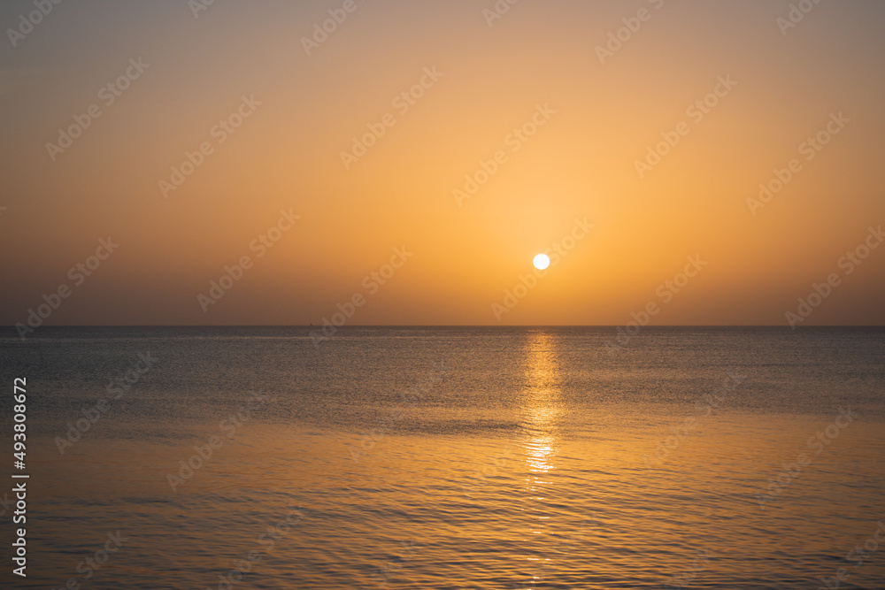 Picturesque golden sunset. Aerial ambient seascape. Peaceful seascape with sun and copy space. Colorful evening sky over tranquil ocean. Golden sunset at the beach. Tropical vacations.