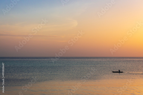 Boat at picturesque sunset. Aerial ambient seascape. Peaceful seascape with sailing boat and copy space. Colorful evening sky over tranquil ocean. Golden sunset at the beach. Tropical vacations. 