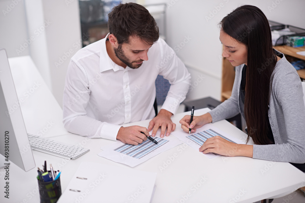Setting up their monthly schedule. Shot of two young business colleagues discussing documents in the office. Setting up their monthly schedule. Shot of two young business colleagues discussing documents in the office.