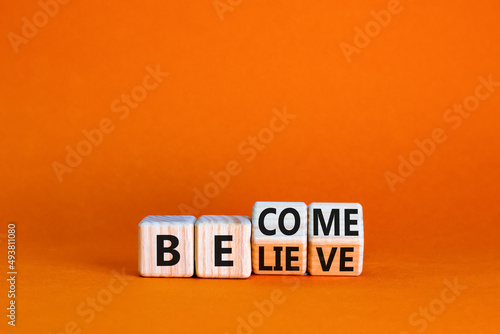 Become or believe symbol. Turned wooden cubes and changed the concept word Believe to Become. Beautiful orange table orange background. Business become or believe concept. Copy space.