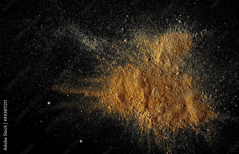 Mixed ginger and turmeric (Curcuma) powder pile isolated on black, top view