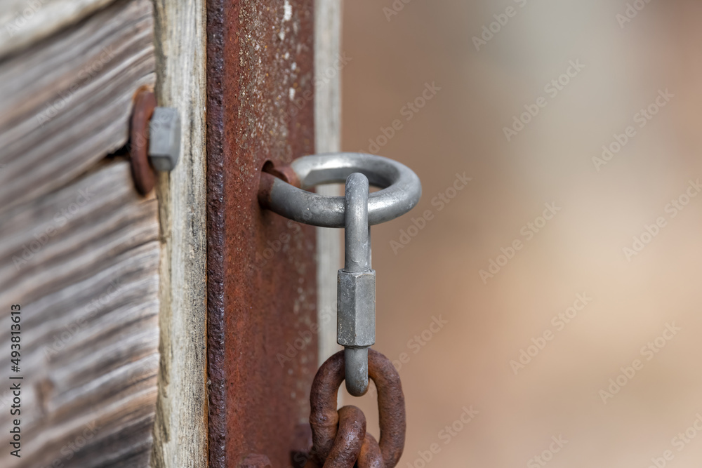 Close up shot of chain mounted to hook on fence, selective focus. Close up shot of chain mounted to hook on fence, selective focus.