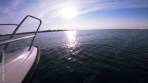 Seascape, view of sea waves with sun reflection from prow of motorboat. Boat jumping on waves on sunny summer day. Yacht motor boat sailing fast at sea horizon. Extreme sport entertainment background photo