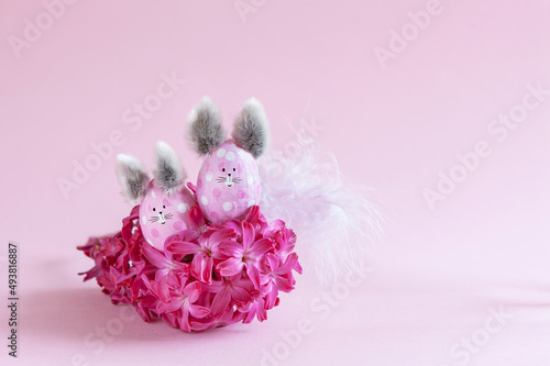 Pink Easter eggs in the form of bunnies on a pink background photo