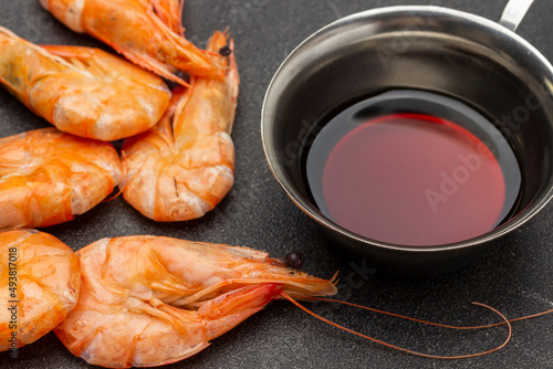 Boiled shrimp and soy sauce in metal bowl.