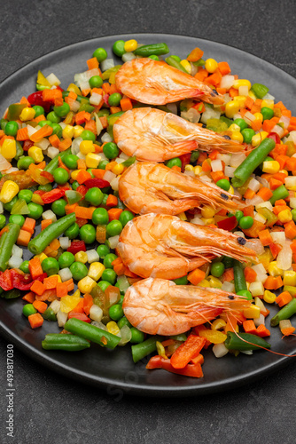 Boiled shrimp and mixed vegetables on black plate