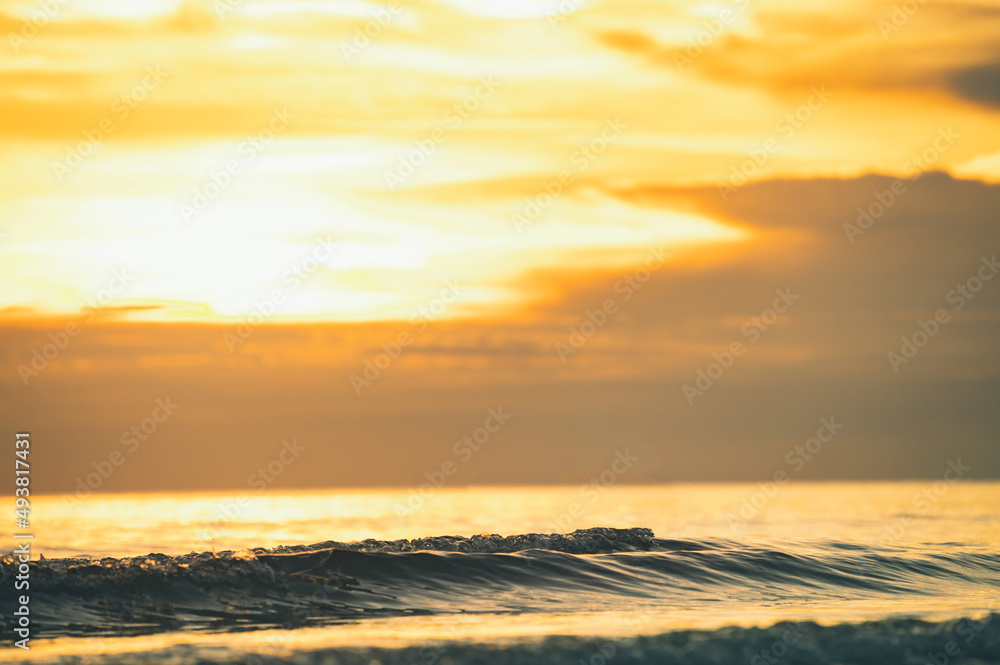 Summer sunset view on the beach. Beautiful blazing sunset landscape and orange sky above it with sun reflection on waves. Summer sunset view on the beach. Beautiful blazing sunset landscape and orange sky above it with sun reflection on waves.