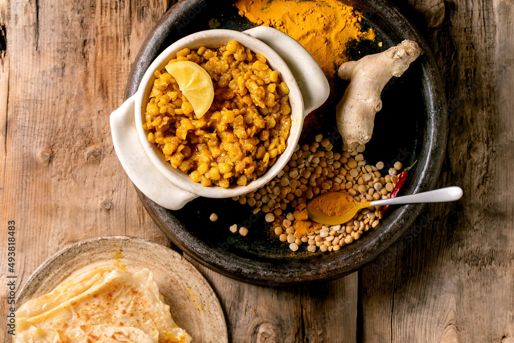 Fototapeta premium Traditional indian yellow pea food dal with roti bread