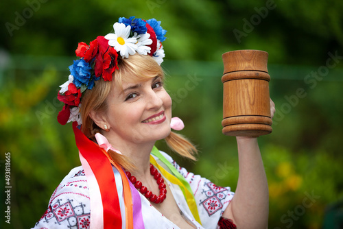 portrait of a Ukrainian woman in national clothes with a beer mug
