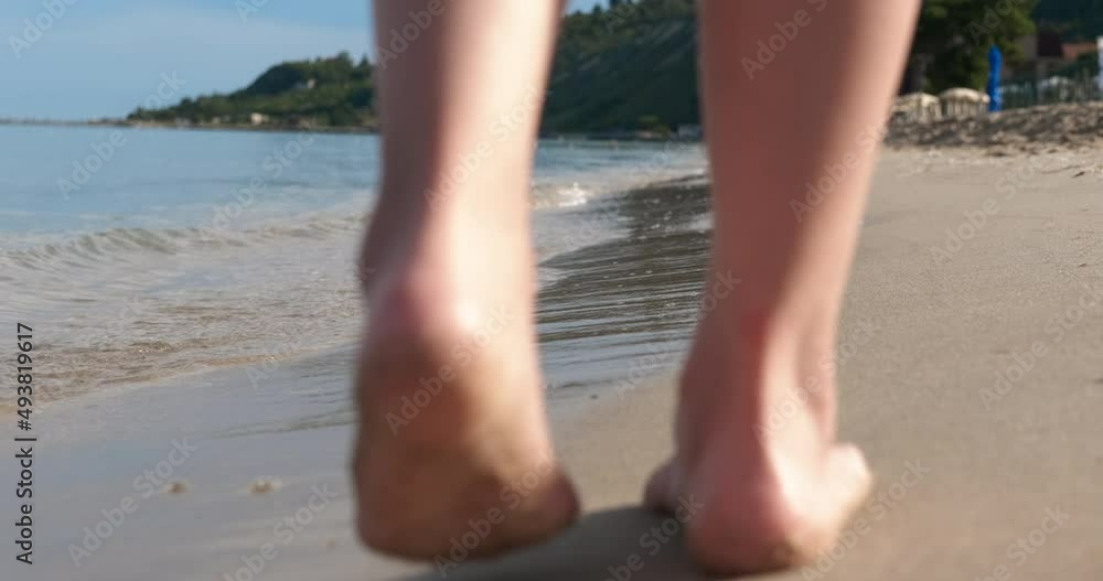 Child walking barefoot on sand. A little girl walking barefoor on the wet sand of the sea during summer vacation. Child walking barefoot on sand. A little girl walking barefoor on the wet sand of the sea during summer vacation.