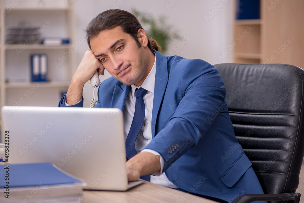 Young male employee sitting in the office Young male employee sitting in the office