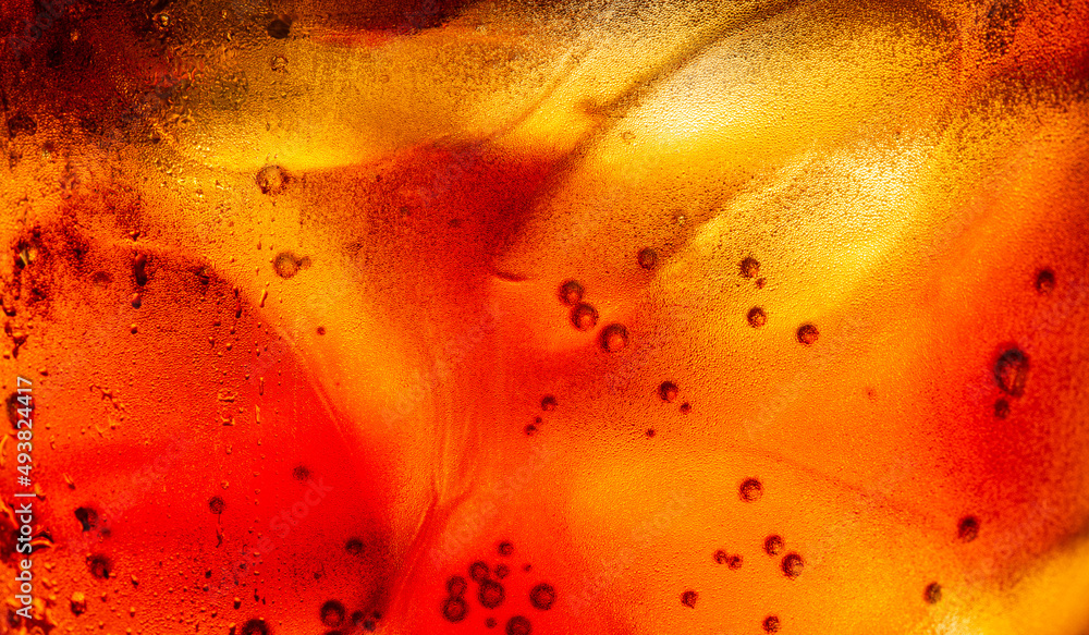 macro soft drink texture,Soft drink glass with ice splash on dark background. Cola glass in celebration party concept. macro soft drink texture,Soft drink glass with ice splash on dark background. Cola glass in celebration party concept.