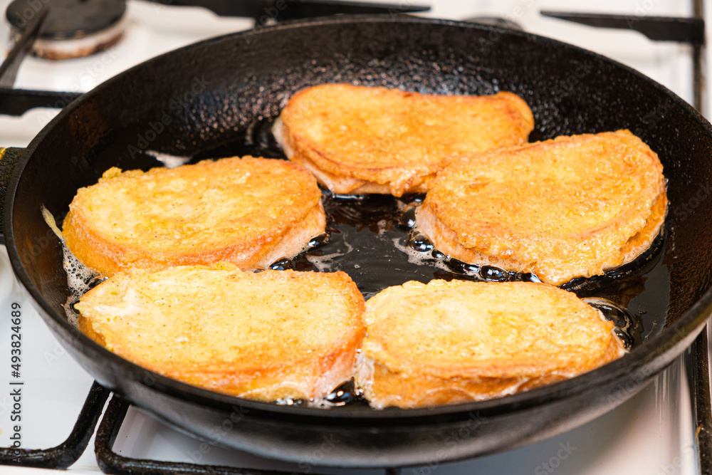 The process of frying bread croutons in an egg in a cast-iron skillet The process of frying bread croutons in an egg in a cast-iron skillet