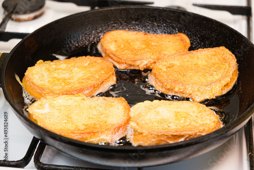 The process of frying bread croutons in an egg in a cast-iron skillet