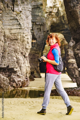 Woman with camera at Cathedral Beach, Galicia Spain.