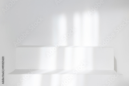 Abstract stand in white studio background for product presentation. Empty room and podium with shadows of window. Display product with blurred backdrop. Soft focus