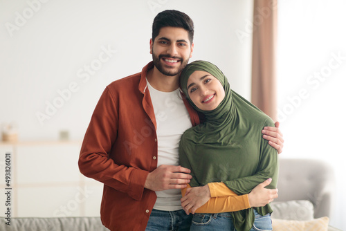 Loving Middle Eastern Couple Embracing Standing At Home