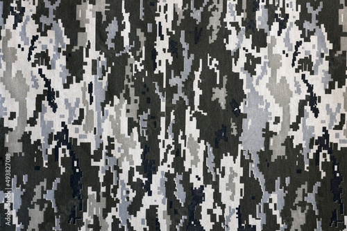 Fabric with texture of Ukrainian military pixeled camouflage. Cloth with camo pattern in grey, brown and green pixel shapes. Official uniform of Ukrainian soldiers photo