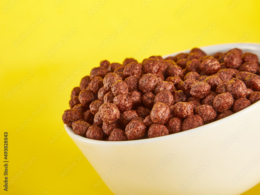 Chocolate Corn balls in bowl over yellow background