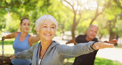 Fototapeta Naklejka Na Ścianę i Meble -  Who said yoga was for the young only. Cropped shot of a group of people practising yoga at the park.
