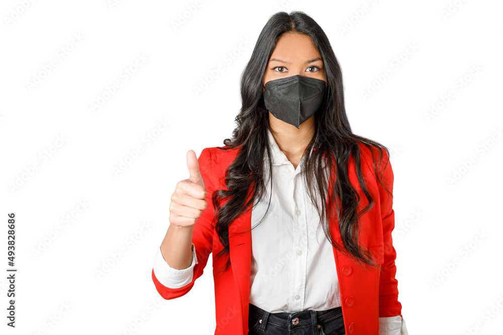 Woman with a KN95 FFP2 black face mask, doing thumb up. Wearing a red blazer. Isolated on white background. 20-22 years old asiatic woman.