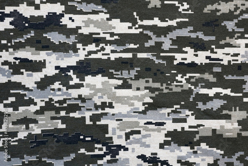 Fabric with texture of Ukrainian military pixeled camouflage. Cloth with camo pattern in grey, brown and green pixel shapes. Official uniform of Ukrainian soldiers photo