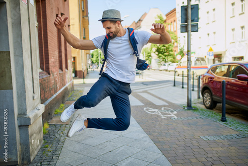 Handsome man dancing jumping on city street