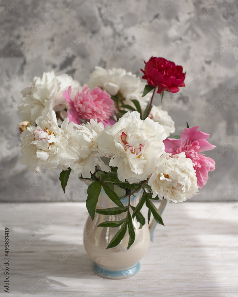 Still life with white and pink peonies in a white vase