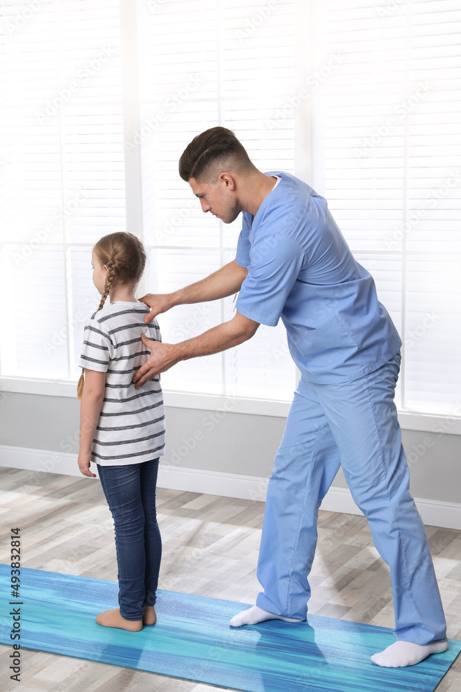 Orthopedist examining child's back in clinic. Scoliosis treatment Orthopedist examining child's back in clinic. Scoliosis treatment