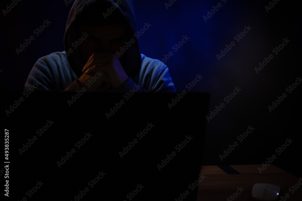 Hacker man working laptop computer. Hacker attack in dark room Hacker man working laptop computer. Hacker attack in dark room