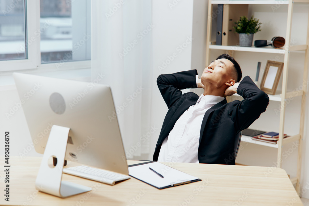 businessmen in a suit sits at a table in front of a computer Lifestyle businessmen in a suit sits at a table in front of a computer Lifestyle