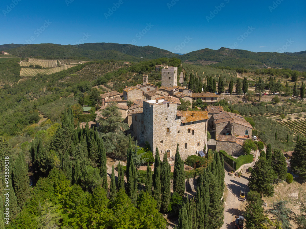 aerial view of old town in tuscany country - medieval castle - blue sky and green land
