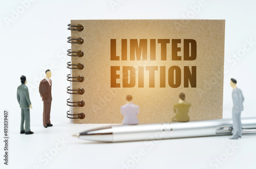 On a white background, figures of businessmen, a pen and a notepad with the inscription - Limited Edition photo