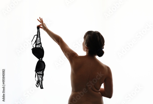 Foto mature woman holding a bra in her hand. concept of feminism.