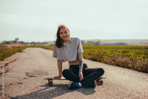 Young cool Woman portrait With Longboard. Girl skater posing on longboard in sunny weather. © Big Shot Theory