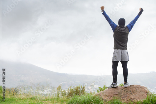 Ive made it to the top. A young man celebrating at the top of a mountain after reachin.