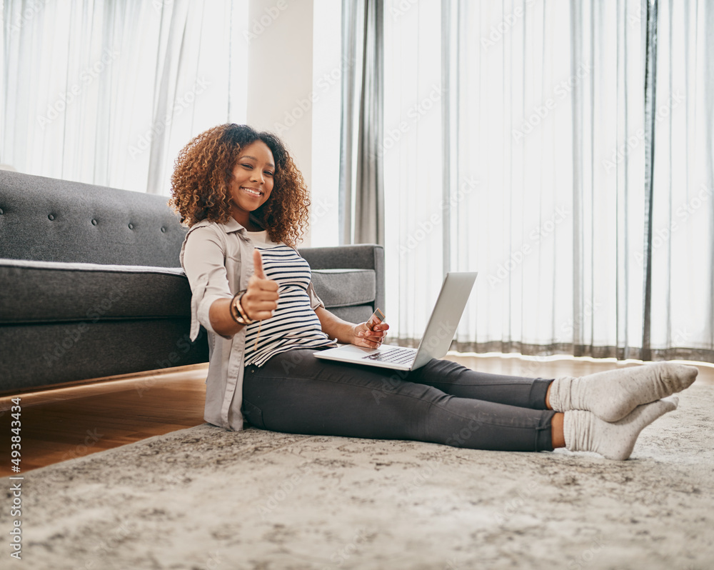 Ive bought all the things I need. Portrait of a cheerful young woman doing online shopping on her laptop while being seated on the floor at home. Ive bought all the things I need. Portrait of a cheerful young woman doing online shopping on her laptop while being seated on the floor at home.