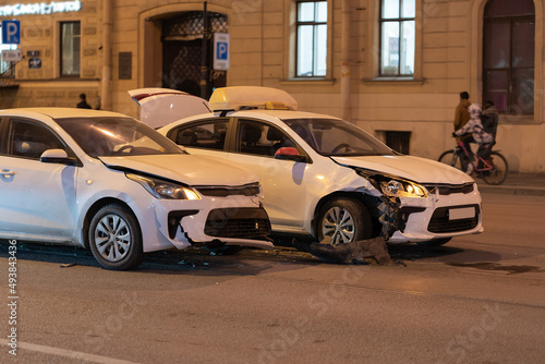 Two cars on the city road after collision. Damaged white automobile on the street after the accident with damaged bumpers, side view.  © DimaBerlin