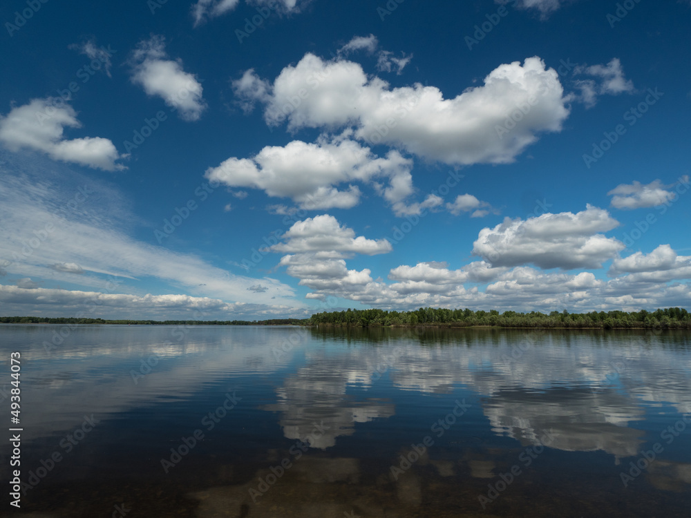 Summer day. River. Clouds over the river Summer day. River. Clouds over the river
