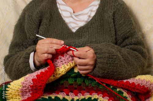 Mujer haciendo crochet con jersey de lana berde, tonos marrones y verdes photo