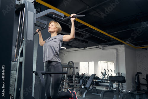 Woman in sportswear having workout with gym equipment